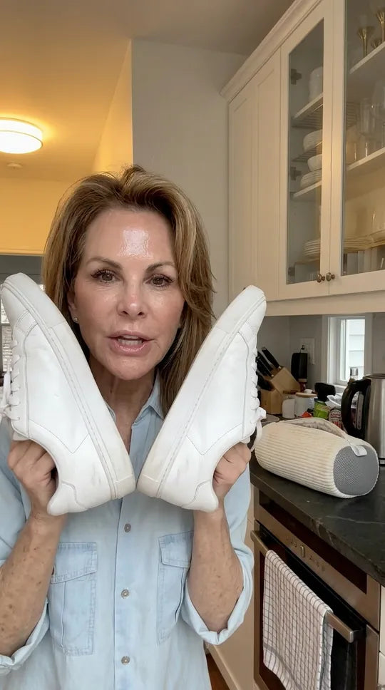 Une paire de sneakers blanches propres, montrée semelles vers l'objectif