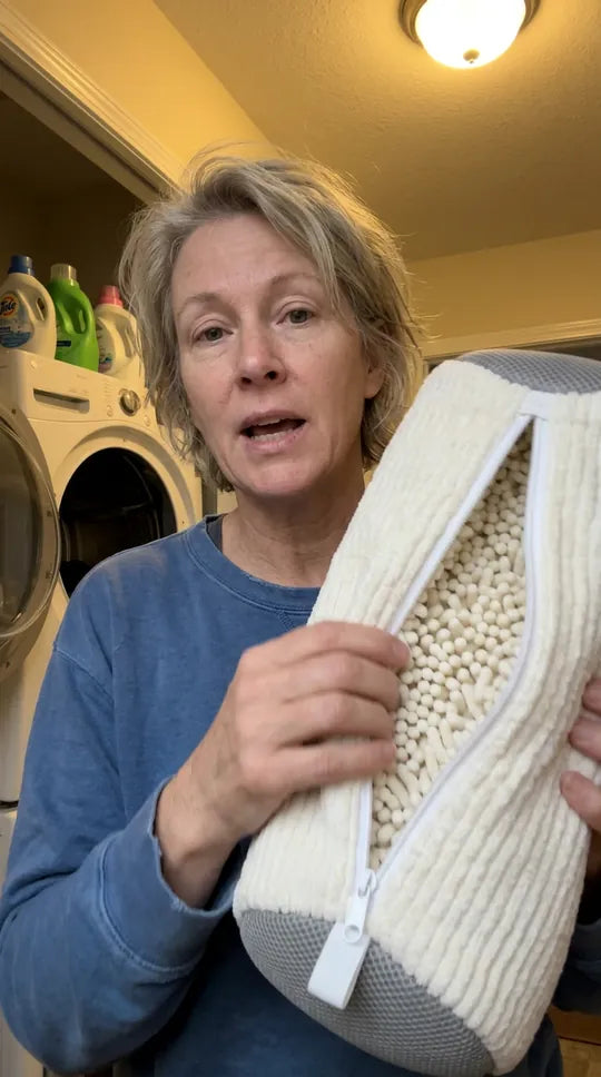 Le sac de lavage Kickow blanc, ouvert sur ses microfibres, devant un lave-linge