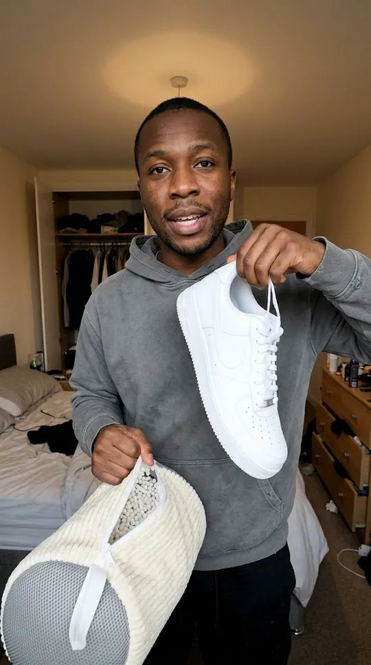 Une sneaker blanche sortie du sac Kickow blanc