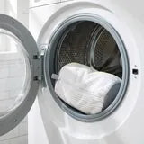 Le sac dans le tambour de la machine, hublot ouvert