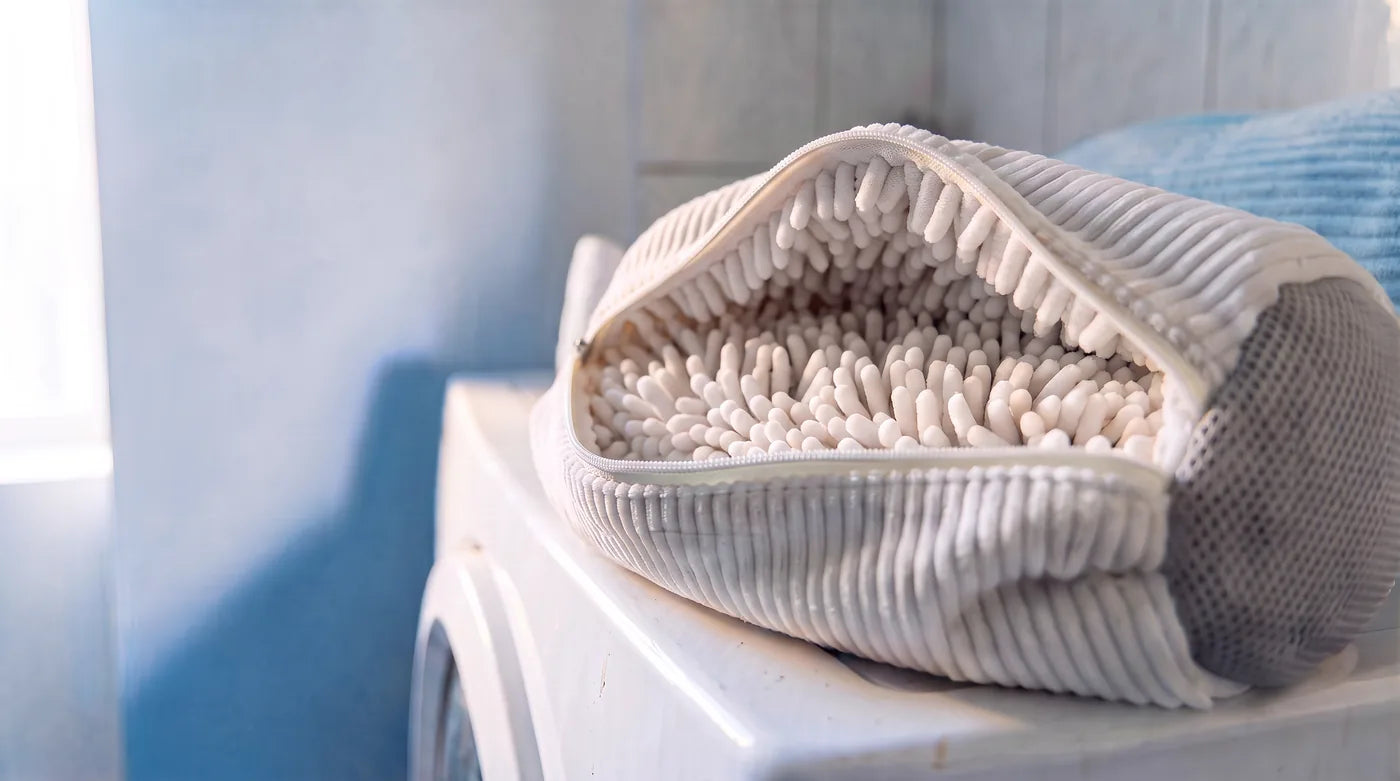 Le sac grand ouvert sur la machine : les franges de microfibre plein cadre